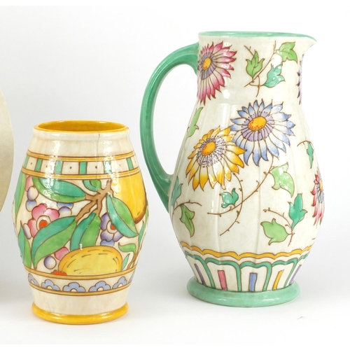 2301 - Bursley Ware by Charlotte Rhead comprising a charger, jug and vase, each hand painted with stylised ... 