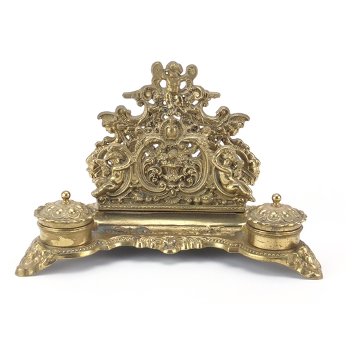 2472 - Victorian style brass desk stand with inkwells and letter rack, decorated with putti, 19cm high