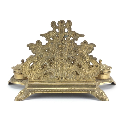 2472 - Victorian style brass desk stand with inkwells and letter rack, decorated with putti, 19cm high