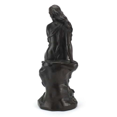 2410 - Bronzed figurine of a seated semi nude female, 39cm high