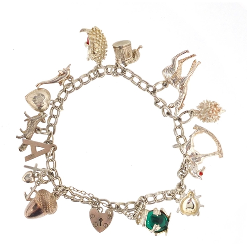 3006 - Two silver charm bracelets with mostly silver charms, including rocking horse, hedgehog and theatre ... 