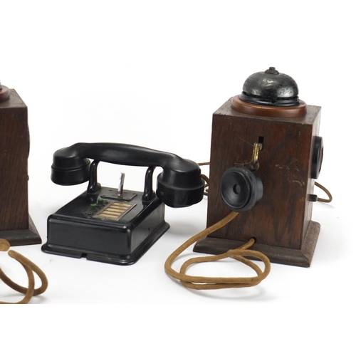 2362 - Two vintage Military interest oak telephones and a black Bakelite example, the largest 24.5cm high