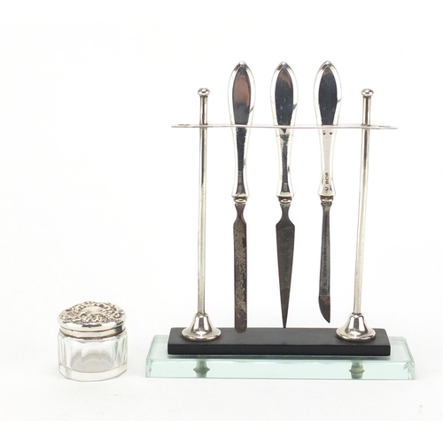 2862 - Silver and glass vanity tool stand with three tools and cut glass jar with silver lid, the stand hal... 