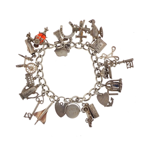 3016 - Silver charm bracelet with a selection of mostly silver charms including Concorde, bird in a cage, c... 