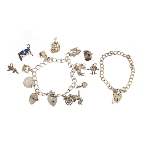 2918 - Two silver charm bracelets with a selection of mostly silver charms, including steam tractor, horse ... 
