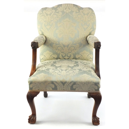2007 - Walnut framed elbow chair carved with lion mask handles and having blue floral upholstery, 97cm high