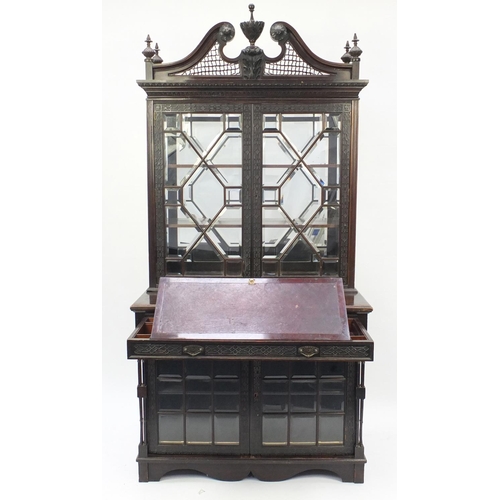 2001 - Chinese Chippendale design bookcase on stand with swan neck pediment, above a pair of glazed doors e... 