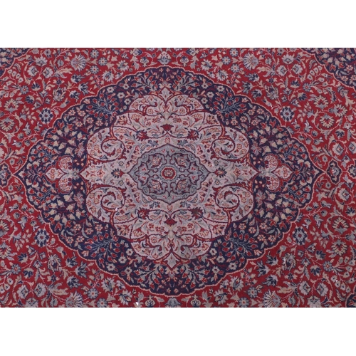 10 - Kerman design rug decorated with flowers onto a predominantly red, blue and cream, ground, 290cm x 2... 