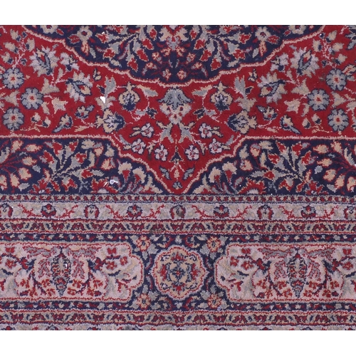 10 - Kerman design rug decorated with flowers onto a predominantly red, blue and cream, ground, 290cm x 2... 
