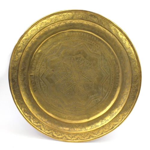 826 - Large circular brass Middle Eastern tray engraved with star and floral motifs, 76cm in diameter