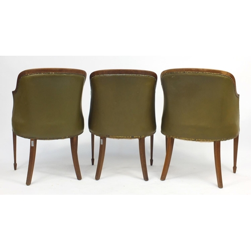 99 - Three Edwardian oak framed tub chairs, with green leatherette upholstery raised on tapering legs, 87... 