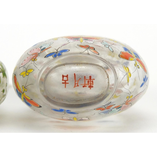 370 - Two Chinese glass snuff bottles with stoppers, each enamelled with butterflies, character marks to t... 