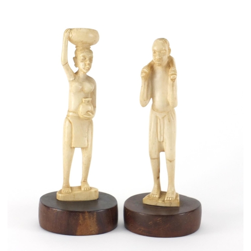 467 - Pair of African ivory carvings of tribes people, raised on circular hardwood bases, the largest 22cm... 