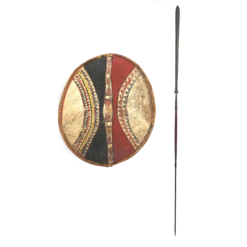 573 - Tribal interest Maasai shield and spear, the shield hand painted with a geometric decoration, the sh... 