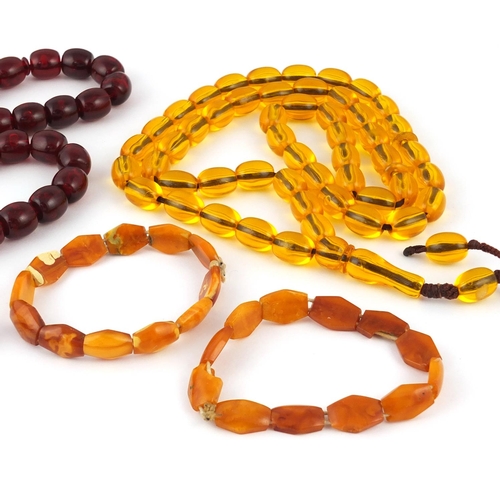 313 - Two amber coloured bead necklaces and two bracelets, the largest 76cm in length, approximate weight ... 