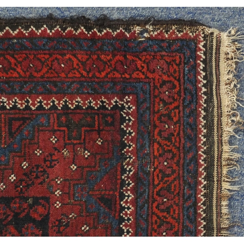 130 - Rectangular Afghan Baluch rug having an all over stylised floral design within corresponding borders... 