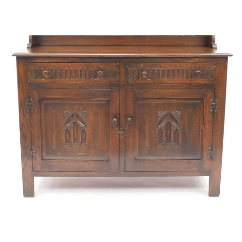 42 - Carved oak dresser with open plate rack above two drawers and a pair of cupboard doors, 167cmH x 128... 