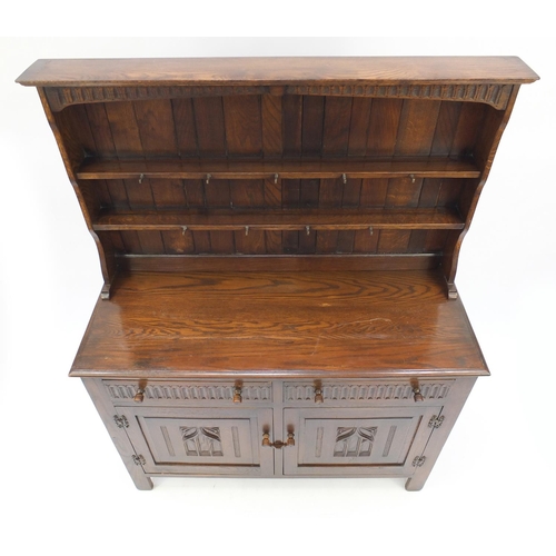 42 - Carved oak dresser with open plate rack above two drawers and a pair of cupboard doors, 167cmH x 128... 