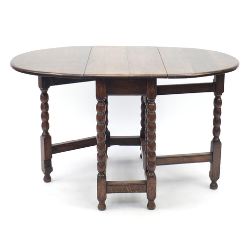 46 - Oak gate leg dining table with bobbin supports and set of four wavy ladder back chairs including two... 