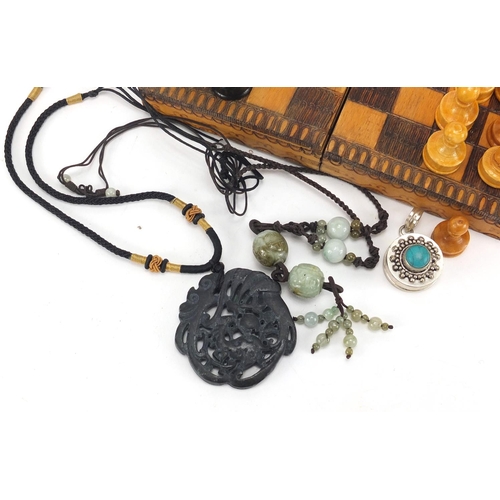 399 - Objects including a Chinese jade necklace, white metal and turquoise pendant and a travel chess set