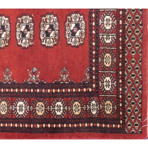 26 - Bokara red ground carpet runner with blue and cream motifs, 237cm x 79cm