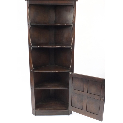 43 - Ercol dark elm corner cupboard fitted with three open shelves, above a cupboard door, 184cm H x 76cm... 