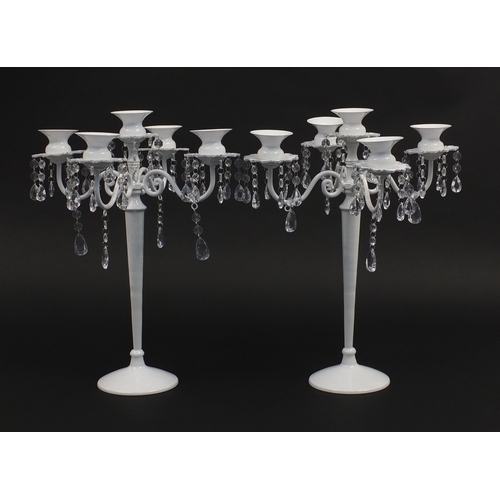 586 - Pair of white painted metal five branch candelabra with crystal design drops, 45cm high