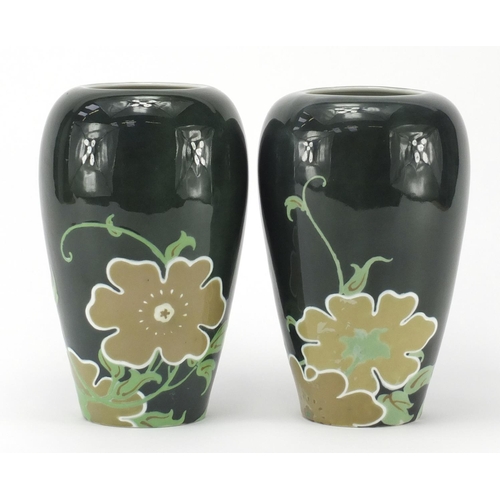 492 - Pair of Japanese porcelain vases, hand painted with flowers onto a green ground, 21cm high