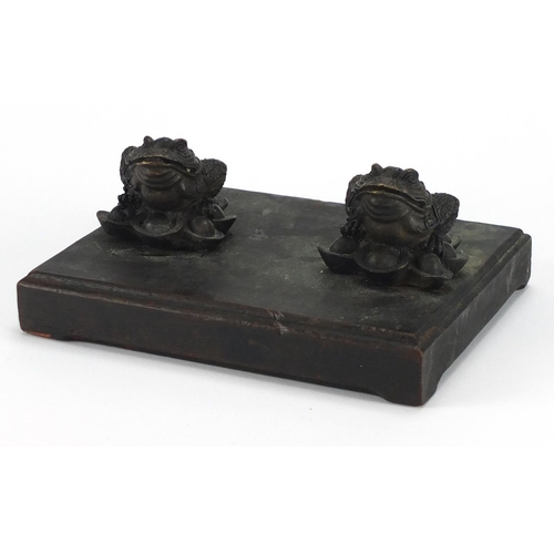 424 - Pair of Chinese bronze toads, mounted onto an oak stand, 19.5cm wide