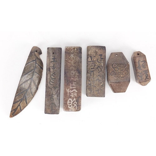 379 - Six Chinese stone pendants carved with calligraphy, the largest 8.5cm in length