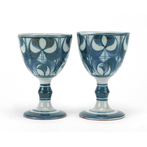 2143 - Pair of Aldernaston pottery goblets, hand painted with stylised fonts, each 14cm high