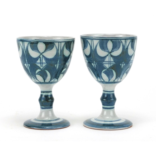 2143 - Pair of Aldernaston pottery goblets, hand painted with stylised fonts, each 14cm high