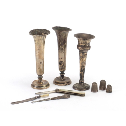 2355 - Silver items comprising three bud vases, three thimbles, mother of pearl flanked fruit knife, page m... 