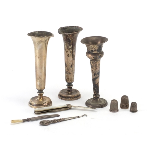 2355 - Silver items comprising three bud vases, three thimbles, mother of pearl flanked fruit knife, page m... 