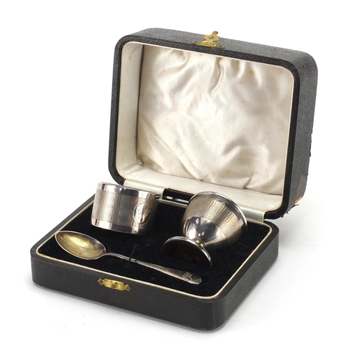 2368 - Silver egg cup, spoon and napkin ring Christening set, with engine turned decoration by Joseph Glost... 
