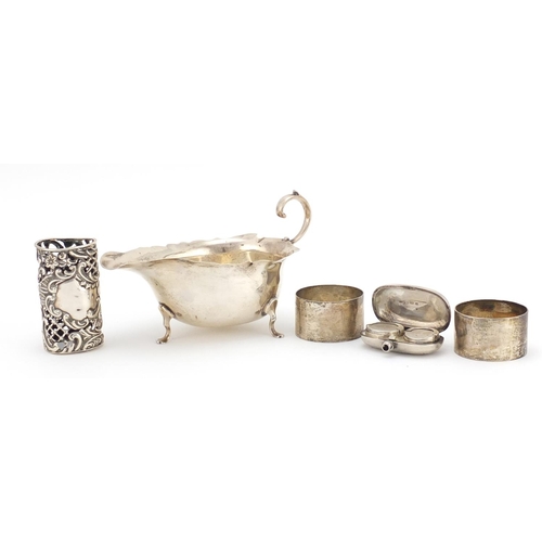 2342 - Silver items comprising three footed sauce boat, pair of napkin rings, a sovereign and half sovereig... 