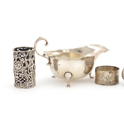 2342 - Silver items comprising three footed sauce boat, pair of napkin rings, a sovereign and half sovereig... 