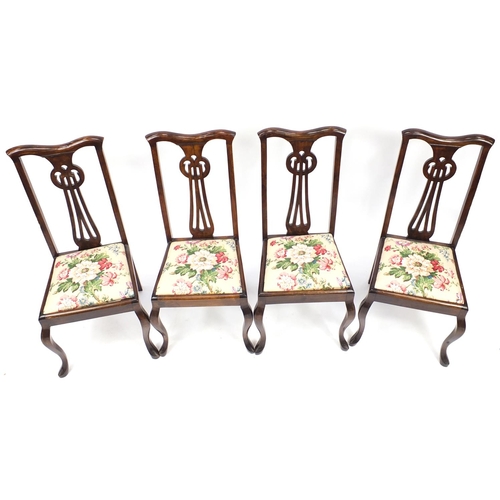 21 - Set of four stained beech chairs with pierced stylised backs, 102cm high