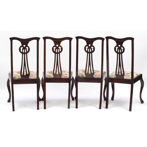 21 - Set of four stained beech chairs with pierced stylised backs, 102cm high