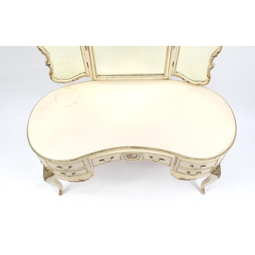 82 - French style cream and gilt kidney shape dressing table with triple mirror and five drawers, the cen... 