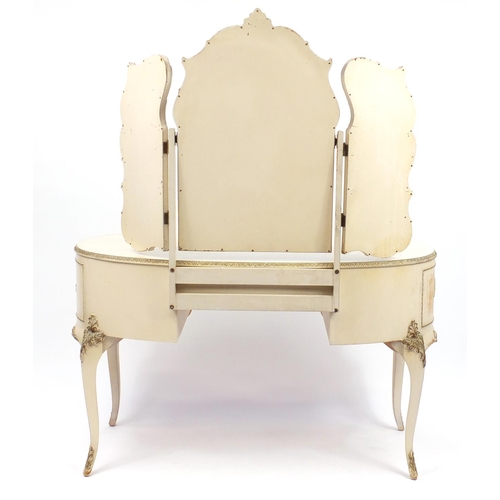 82 - French style cream and gilt kidney shape dressing table with triple mirror and five drawers, the cen... 