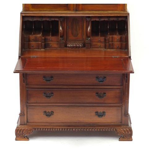 2022 - Mahogany bureau bookcase with a pair of astragal glazed doors, above a fall and four drawers on carv... 