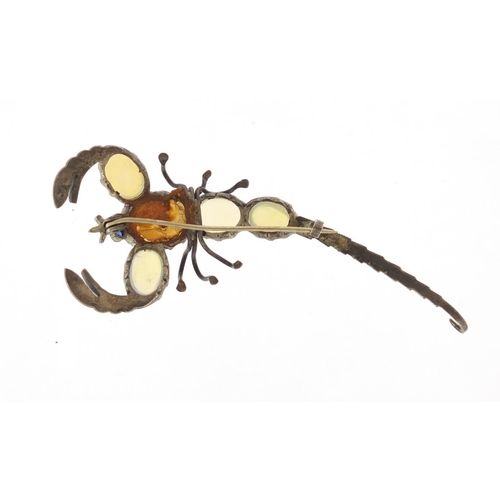 631 - Unmarked silver and opal scorpion brooch with sapphire eyes, 7cm in length, approximate weight 8.0g