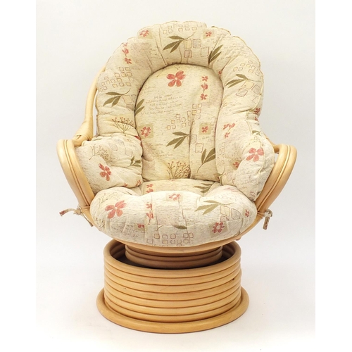 111 - Cane conservatory swivel tub chair with floral upholstered cushions, 100cm high