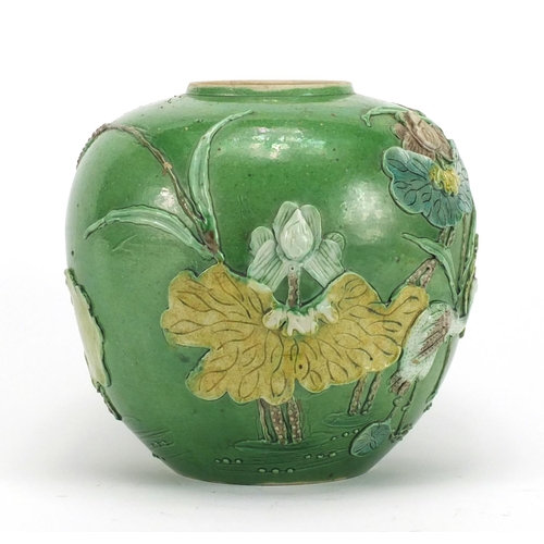 224 - Chinese porcelain green glazed jar, decorated in relief with a craned amongst flowers and reeds, 15.... 