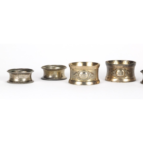 2540 - Set of five circular silver napkin rings and a pair of silver coloured metal napkin rings, approxima... 