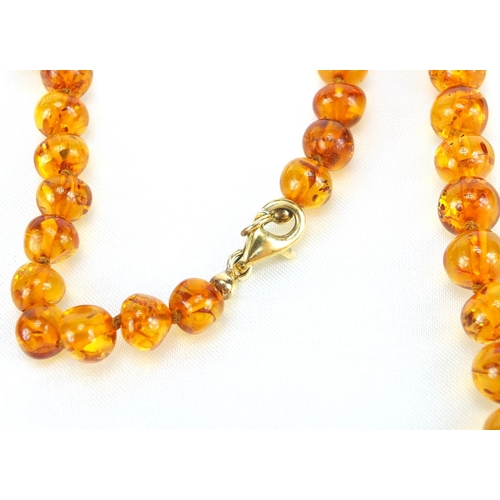 411 - Natural amber bead necklace with silver gilt clasp
