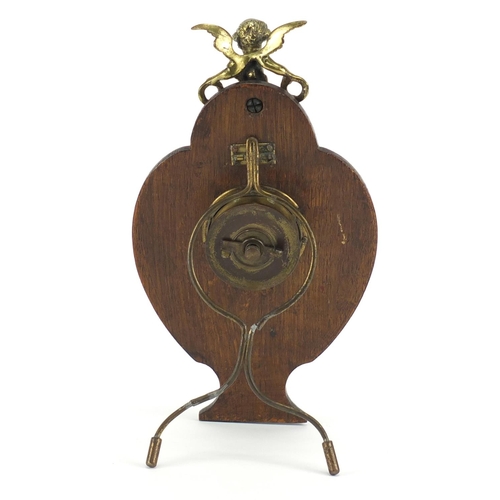 735 - Victorian oak and brass easel clock mounted with putti, 26.5cm high