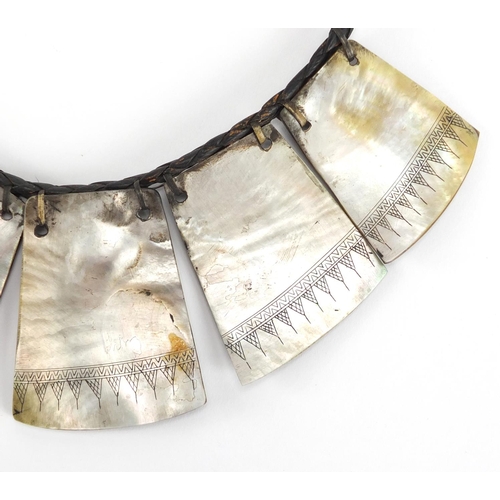 363 - Tribal mother of pearl waist garment, carved with tribal motifs, 38cm in length