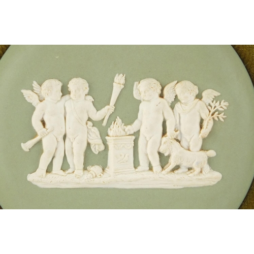 414 - Two Wedgwood green Jasper Ware plaques including one of a maiden, each in a gilt frames, impressed m... 